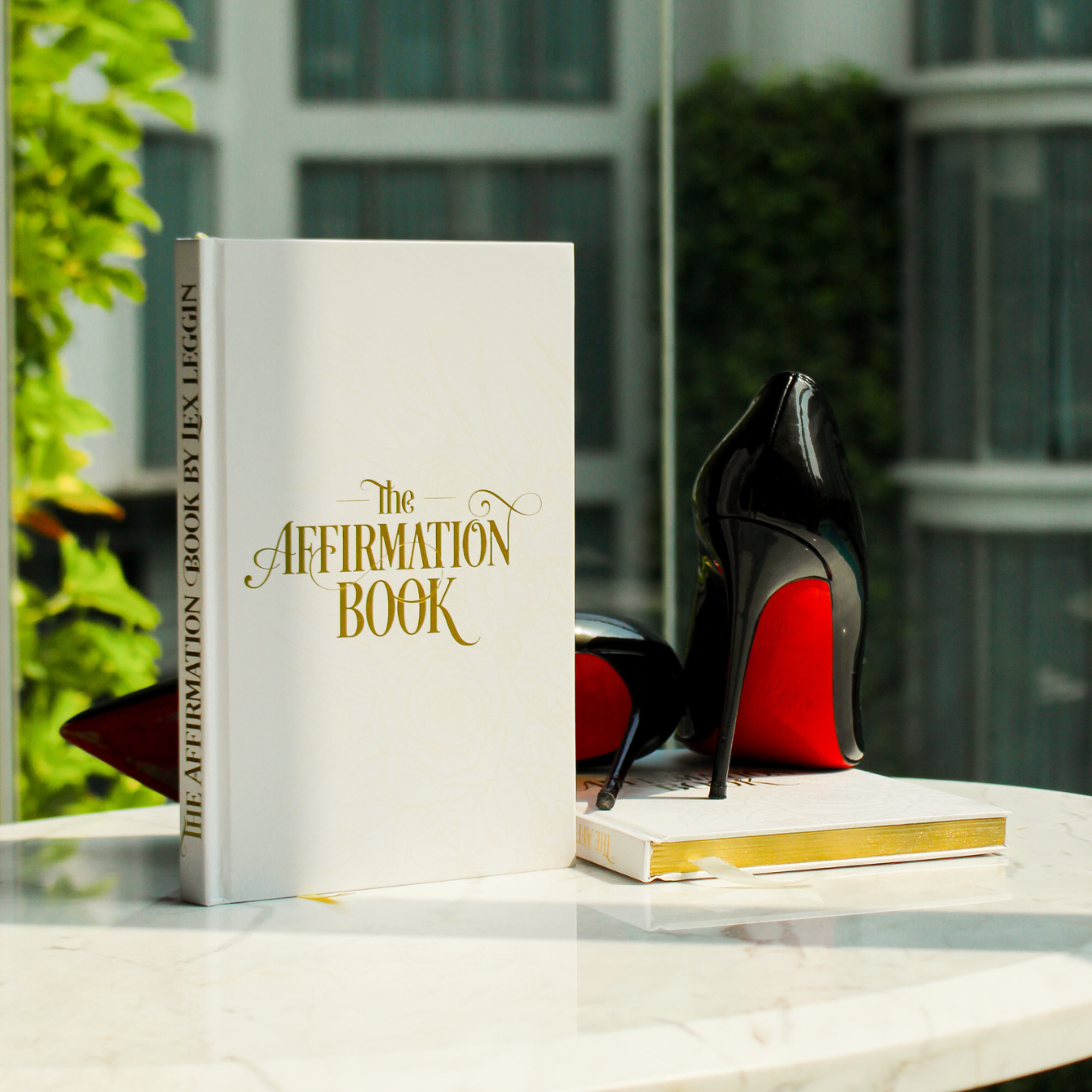 Two physical product photos of The Affirmation Book by Lex Leggin, displaying the elegant hardcover design from different angles.